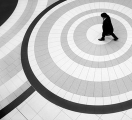 High angle view of man in coat and hat walking on tiled floor