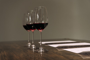 documents and wine glasses on wooden table in restaurant