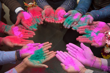 Group of people holding colorful powder paint in hands
