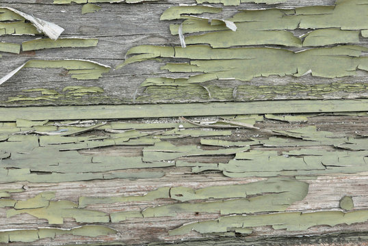 Wood with flaking pale green paint