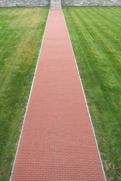 Straight red brick path in a lawn