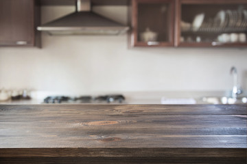 Modern kitchen with empty wooden tabletop. Blurred background.