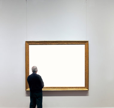 Rear view of man looking at empty gilded frame in art gallery