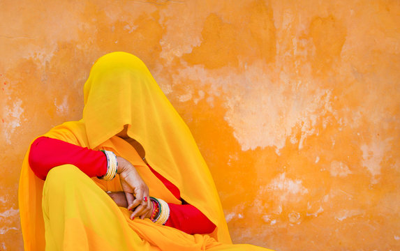 Woman in sari sitting near wall