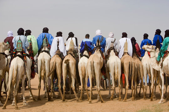 Rear view of men riding camels in desert
