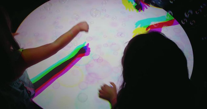 colorful hands popping bubbles children having fun playing with multicolor light kids playing game with rainbow colors happy childhood concept