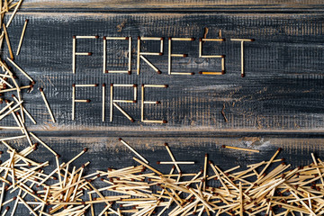 inscription forest fire of matches on burnt board. copy space. Lettering.