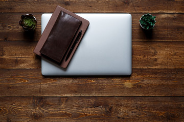work space of a businessman. view from above . coffee notebook and laptop on the desktop with black note.