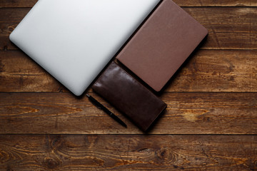 work space of a businessman. view from above . coffee notebook and laptop on the desktop with black note.