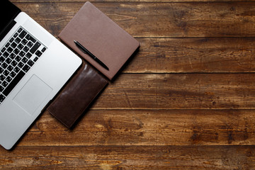 work space of a businessman. view from above . coffee notebook and laptop on the desktop with black note.