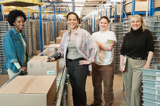 Portrait of smiling workers standing in distribution warehouse