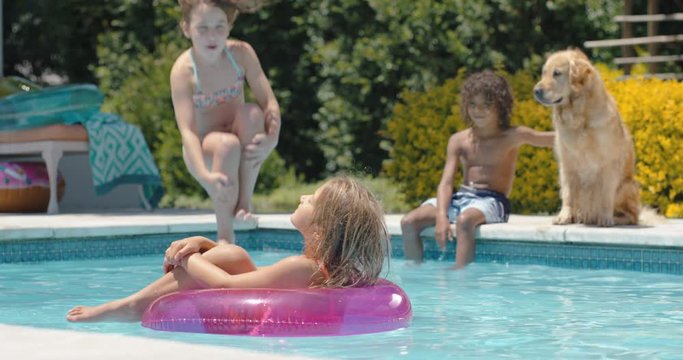 funny little girl jumping in swimming pool splashing friend on swim tube kids playfully having fun together summer day 4k