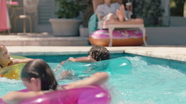 happy children swimming in pool with colorful swim tube inflatable toys kids splashing playfully having fun together on water floats enjoying summer vacation