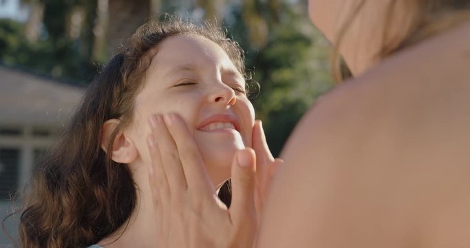 mother applying sunscreen lotion on daughters skin for sun protection little girl getting ready to swim in pool with mom using sunblock caring for childs health on sunny day 4k