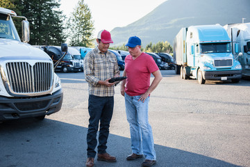 Truck drivers using digital tablet at truck stop