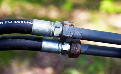 two rubber hoses in Umea with bolts, screw thread and size written in white text