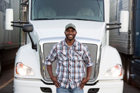 Portrait of truck driver standing near truck at truck stop