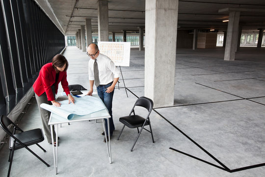 Architects talking over blueprint