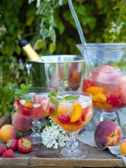 fruit cruchon cocktail punch in jug and glasses with ice and fruit
