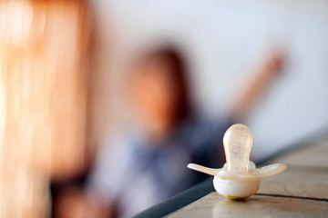 Fototapeta premium Pacifier on a table next to a child.