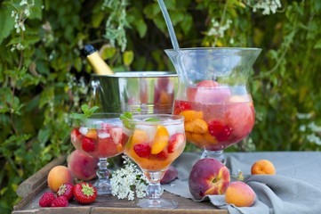 fruit cruchon cocktail punch in jug and glasses with ice and fruit