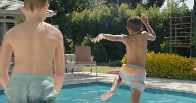 happy kids jumping in swimming pool friends splashing playfully having fun together on sunny day enjoying cool water on summer vacation at holiday home 4k