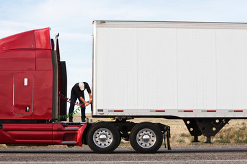 Man connecting power cables to cab and trailer