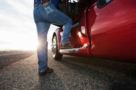 Low section of man getting into commercial truck