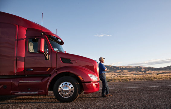 Side view of man leaning on commercial truck