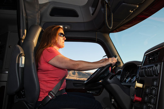 Side view of woman driving commercial truck