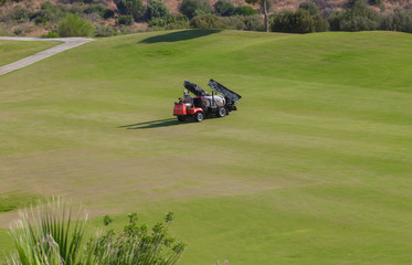 Sprayer machine performing maintenance at golf course. Shelf propelled vehicle