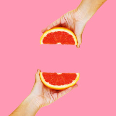 Grapefruit in hand on a bright background. Modern art collage