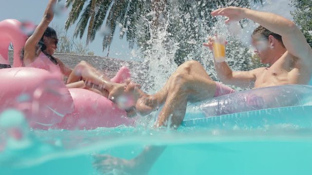 pool party funny man jumping in swimming pool splashing friends on swim tubes having fun people celebrating summer vacation on colorful swim floats enjoying summertime 4k
