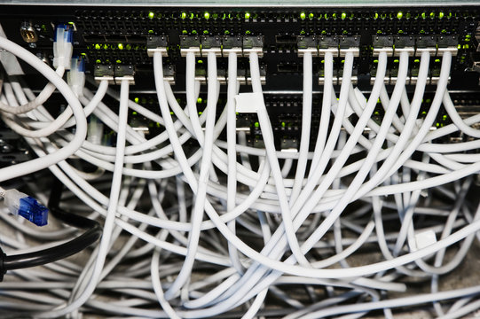 Close up of cat 5 cables hooked to servers in computer server room