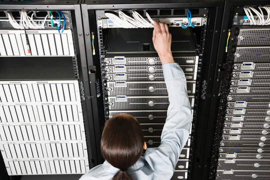 Rear view of technician working in computer server room