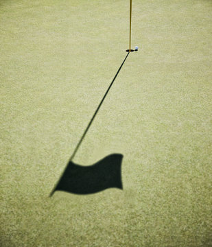 Shadow of golf flag on golf course