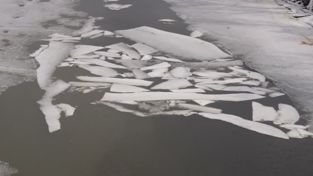 The river bank, waves of dirty melt snow water