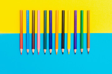 Back to scool - Pencils detail. Colored sharp pencils detail in a row, isolated on blue and yellow.
