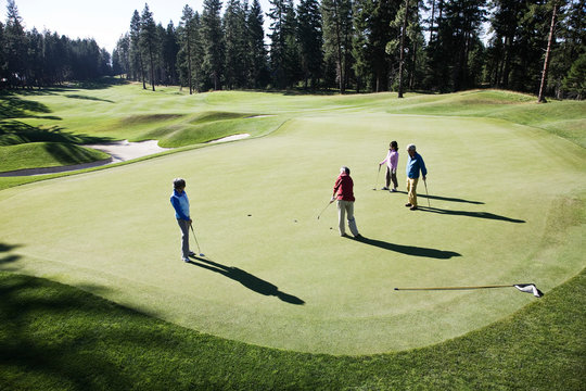 Senior couples playing golf on golf course