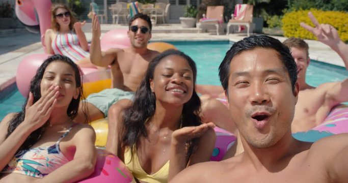 friends in swimming pool young asian man taking video using smartphone sharing summer vacation on social media happy people enjoying summer day outdoors 4k