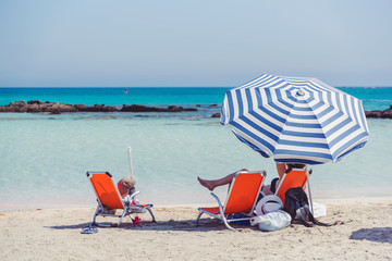 Sunbeds and umbrella of beautiful Mediterranean beach summer vacation concept