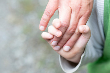 Ein Kind hält die Hand einer erwachsenen Frau