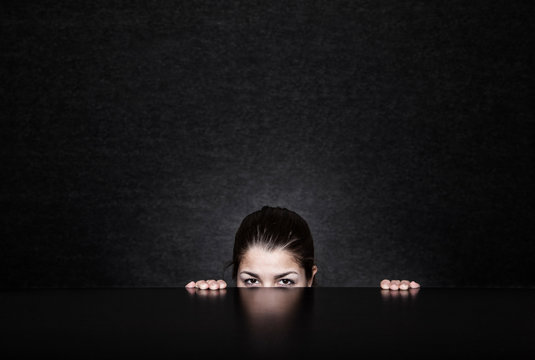 Portrait of woman peeping under the table