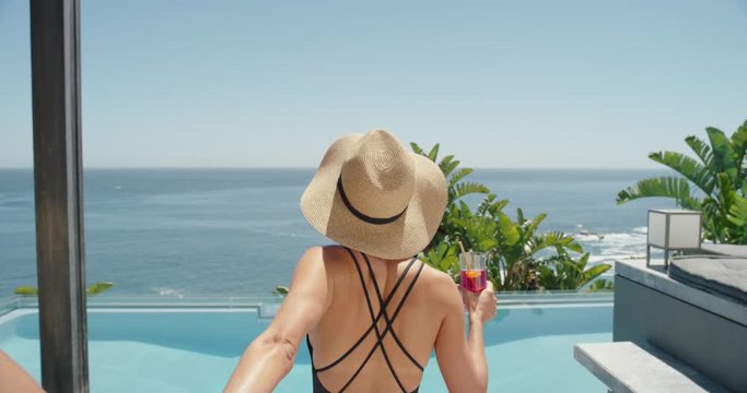 travel couple holding hands woman leading boyfriend by swimming pool at luxury hotel resort with view of ocean enjoying exotic summer vacation wearing sexy bikini pov 4k