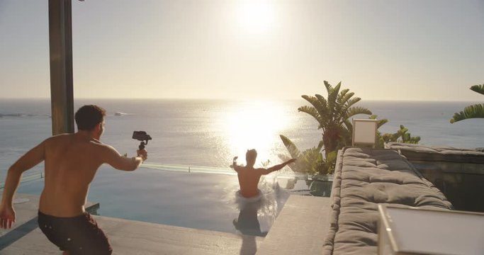 man using smartphone taking video of friend jumping in swimming pool having fun sharing travel vacation lifestyle on social media 4k