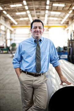 Portrait of smiling manager standing in factory