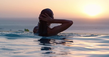 travel woman swimming in pool at luxury hotel spa with beautiful sunset view of ocean mediterranean travel holiday resort relaxing lifestyle freedom 4k - Powered by Adobe