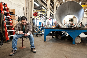 Worker using mobile phone in factory