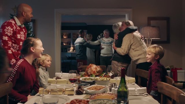 christmas family hugging arriving for dinner party celebrating festive holiday reunion with friends enjoying season greeting at home 4k footage - Powered by Adobe