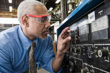 Manager checking gauges in factory